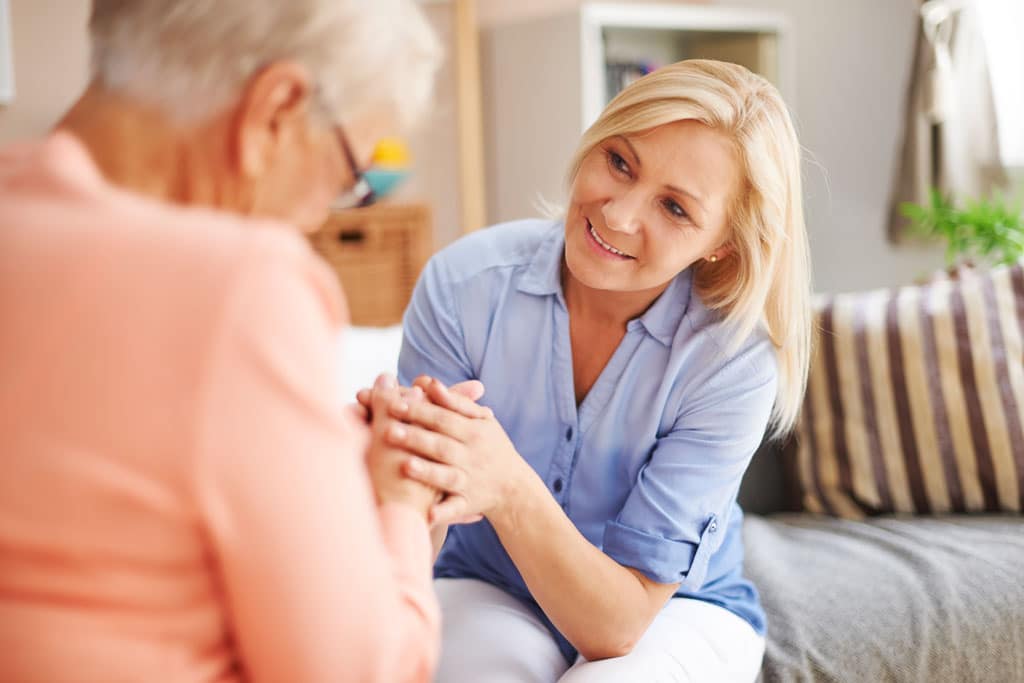 Krankenschwester führt ein Gespräch mit einer älteren Frau und zeigt einen bedeutungsvollen Austausch von Worten und Emotionen.